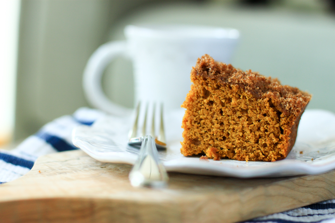 a slice of Pumpkin Coffee Cake on a plate and a cup of coffee