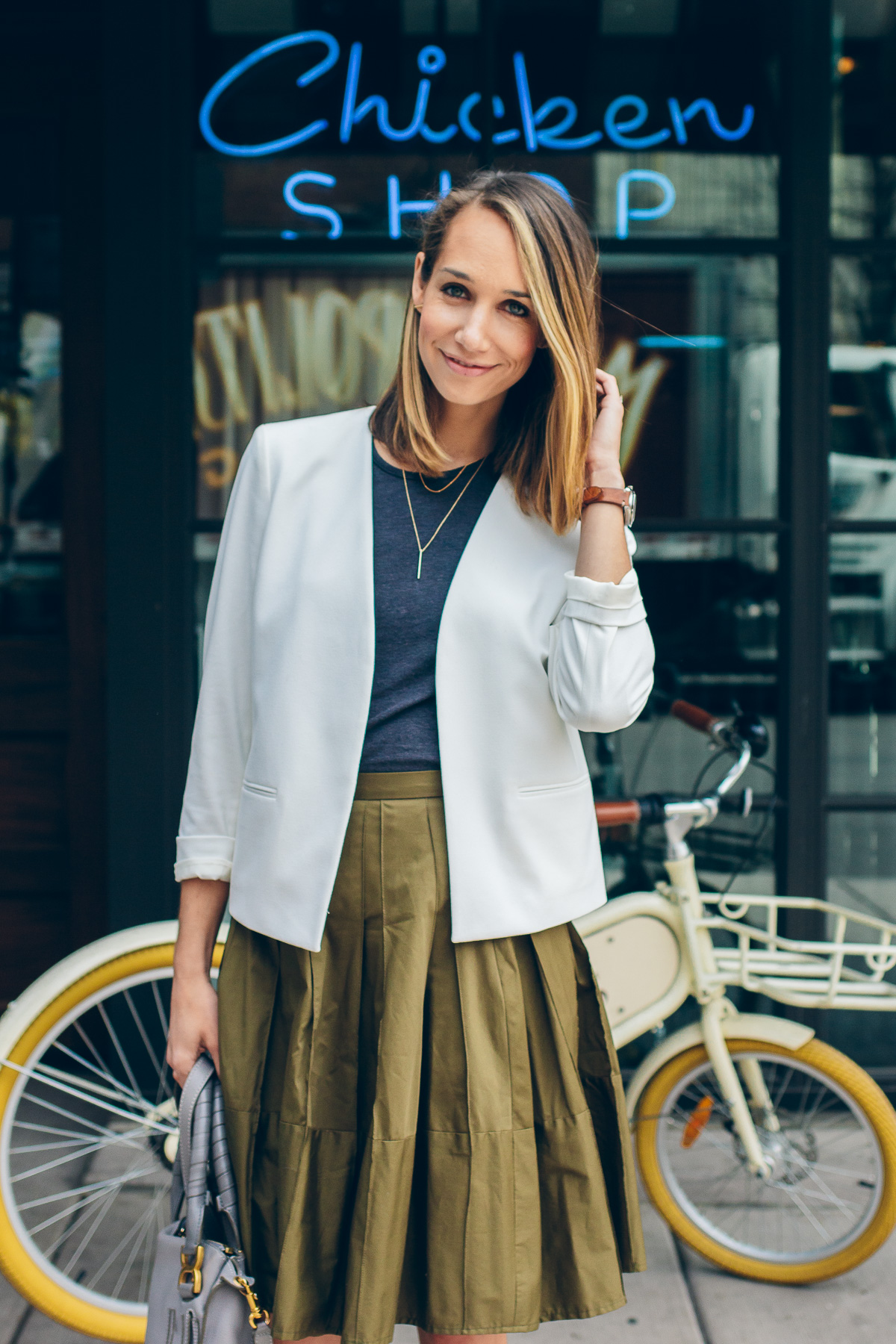 white blazer, grey tank and a pleated skirt