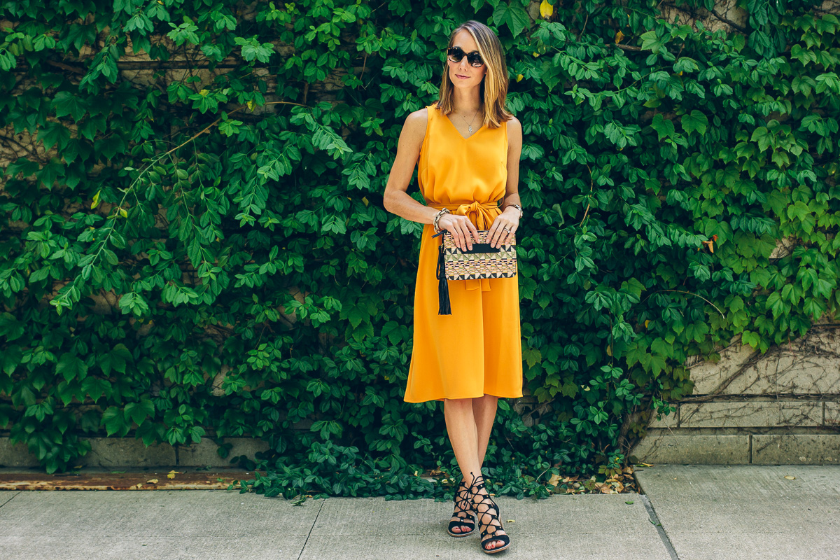 yellow tie dress with straw tassel clutch and lace up heels