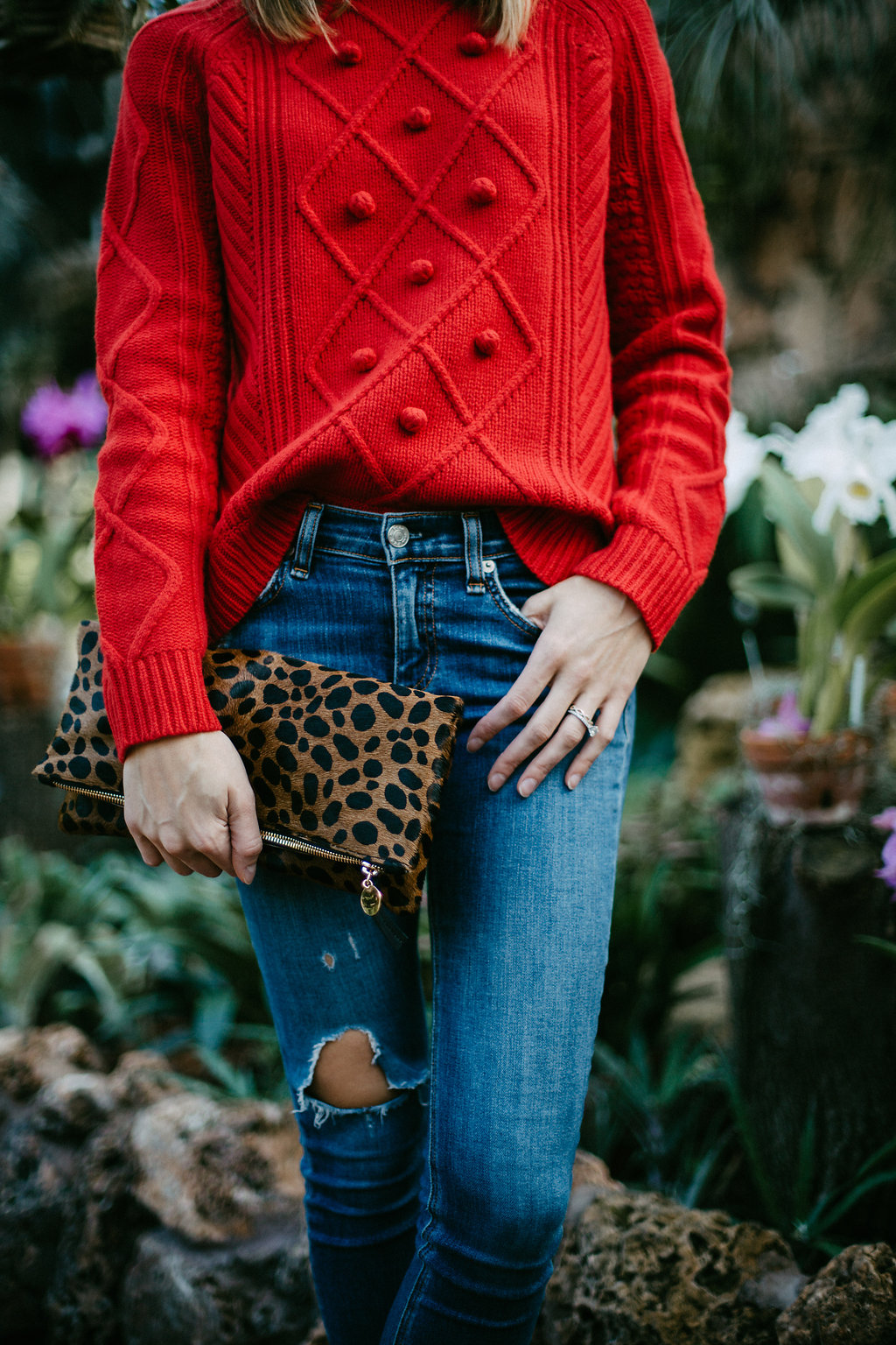 red pom pom sweater and leopard clutch