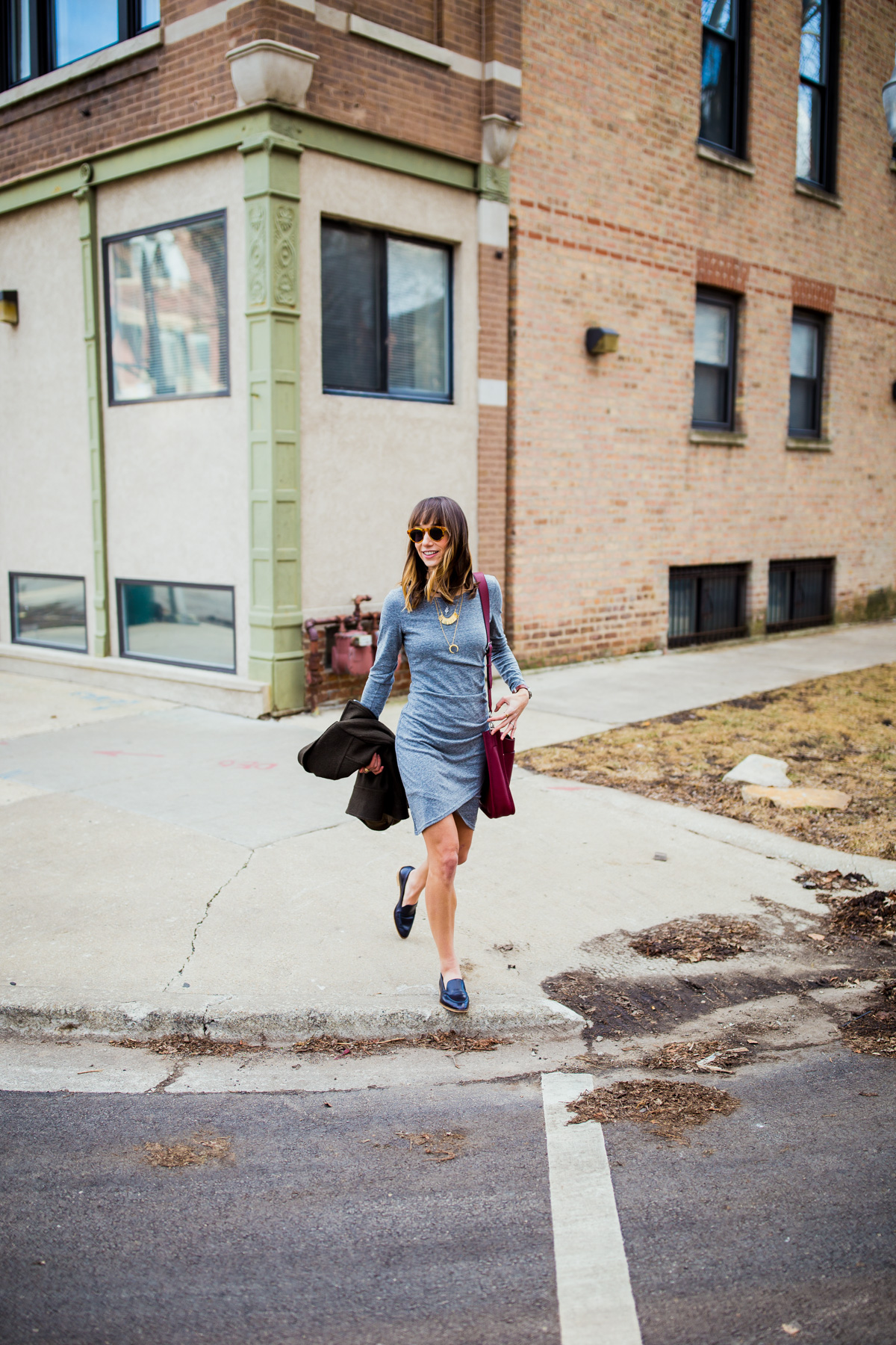 casual outfit—grey dress, feed bag, moto jacket and modern loafers