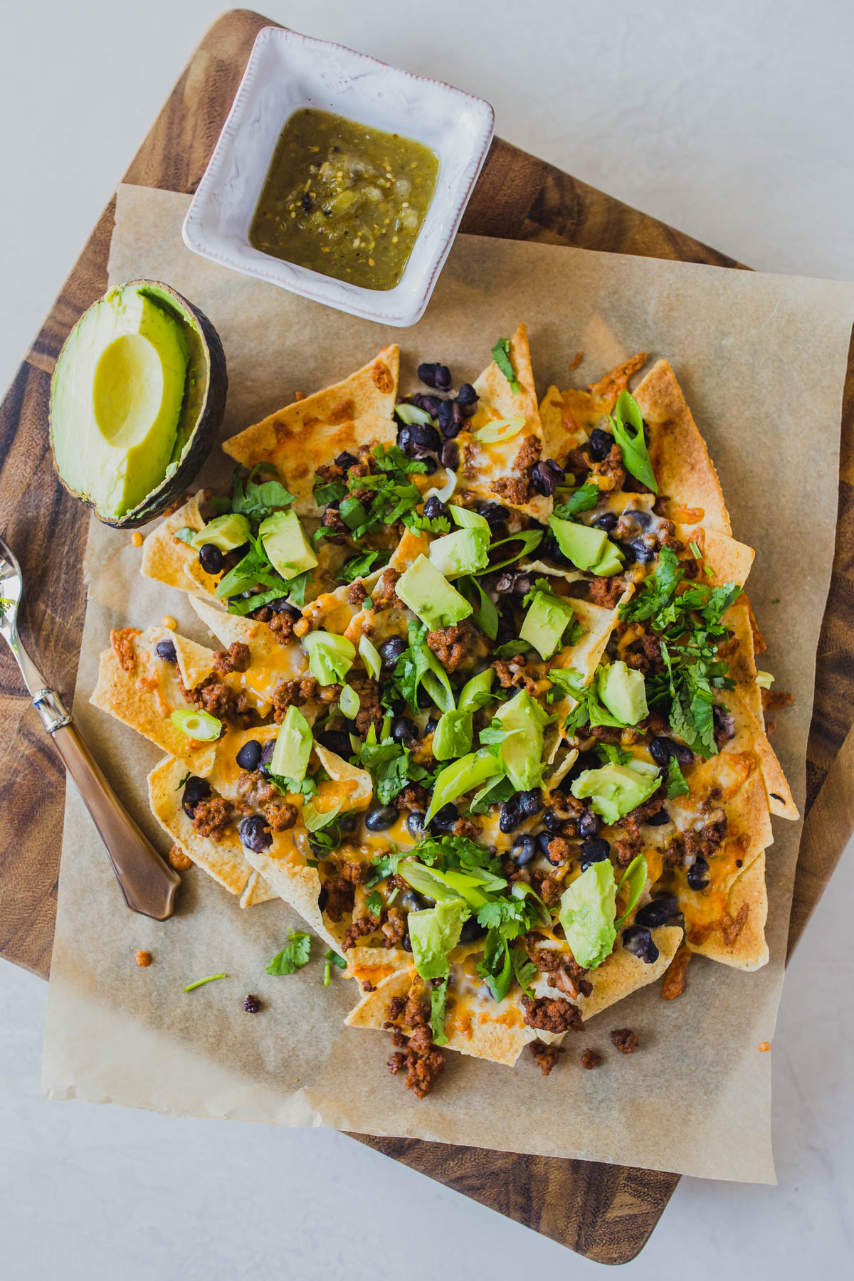 Looking for easy grain free dinners? These sheet pan beef nachos are so simple and so delicious! You only need a few ingredients like grassfed ground beef, black beans, Siete tortilla chips, avocado, cilantro and grated cheese for this easy grain free dinner. Click through for how to make these clean eating healthy nachos. #healthynachos #cleaneating #grainfree #grassfedbeef