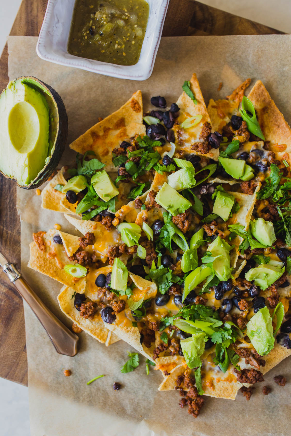Looking for easy grain free dinners? These sheet pan beef nachos are so simple and so delicious! You only need a few ingredients like grassfed ground beef, black beans, Siete tortilla chips, avocado, cilantro and grated cheese for this easy grain free dinner. Click through for how to make these clean eating healthy nachos. #healthynachos #cleaneating #grainfree #grassfedbeef