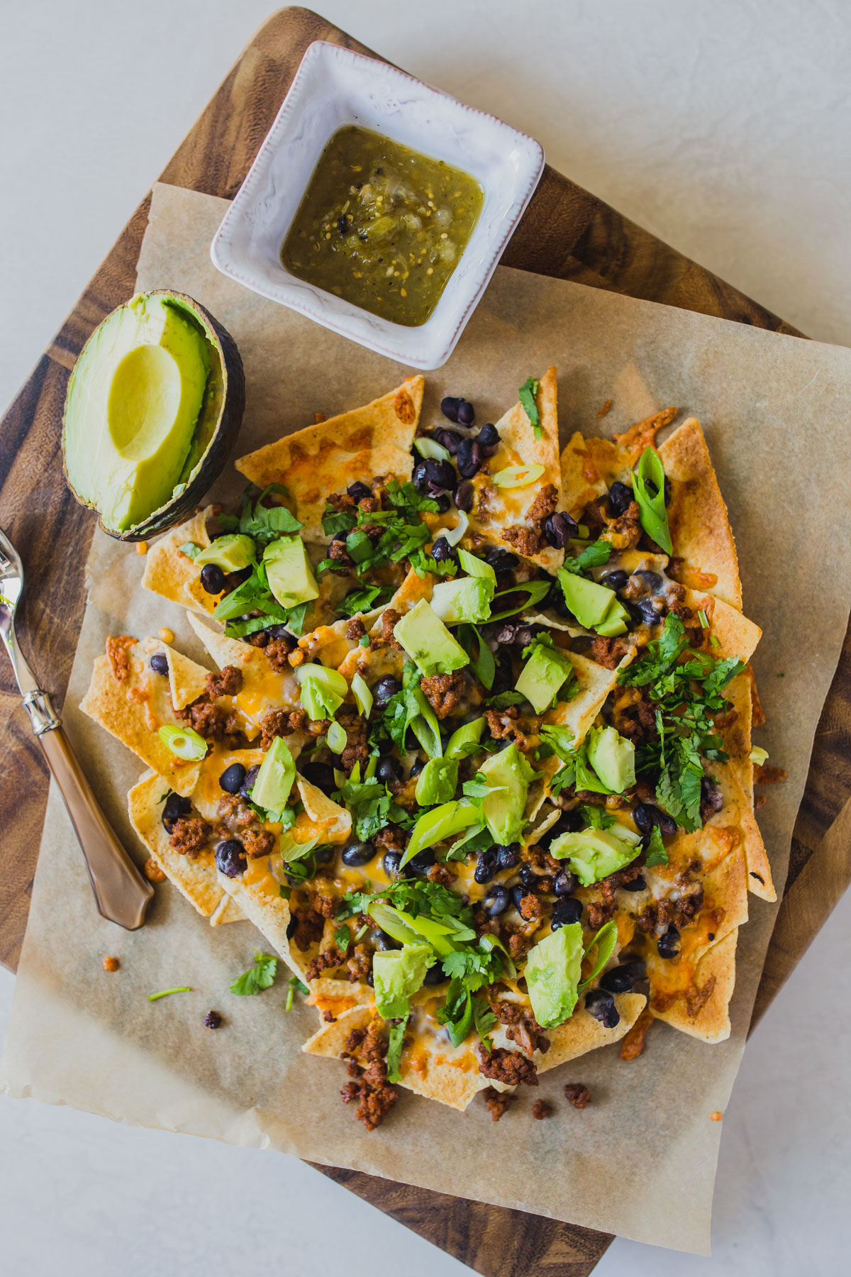 Looking for easy grain free dinners? These sheet pan beef nachos are so simple and so delicious! You only need a few ingredients like grassfed ground beef, black beans, Siete tortilla chips, avocado, cilantro and grated cheese for this easy grain free dinner. Click through for how to make these clean eating healthy nachos. #healthynachos #cleaneating #grainfree #grassfedbeef