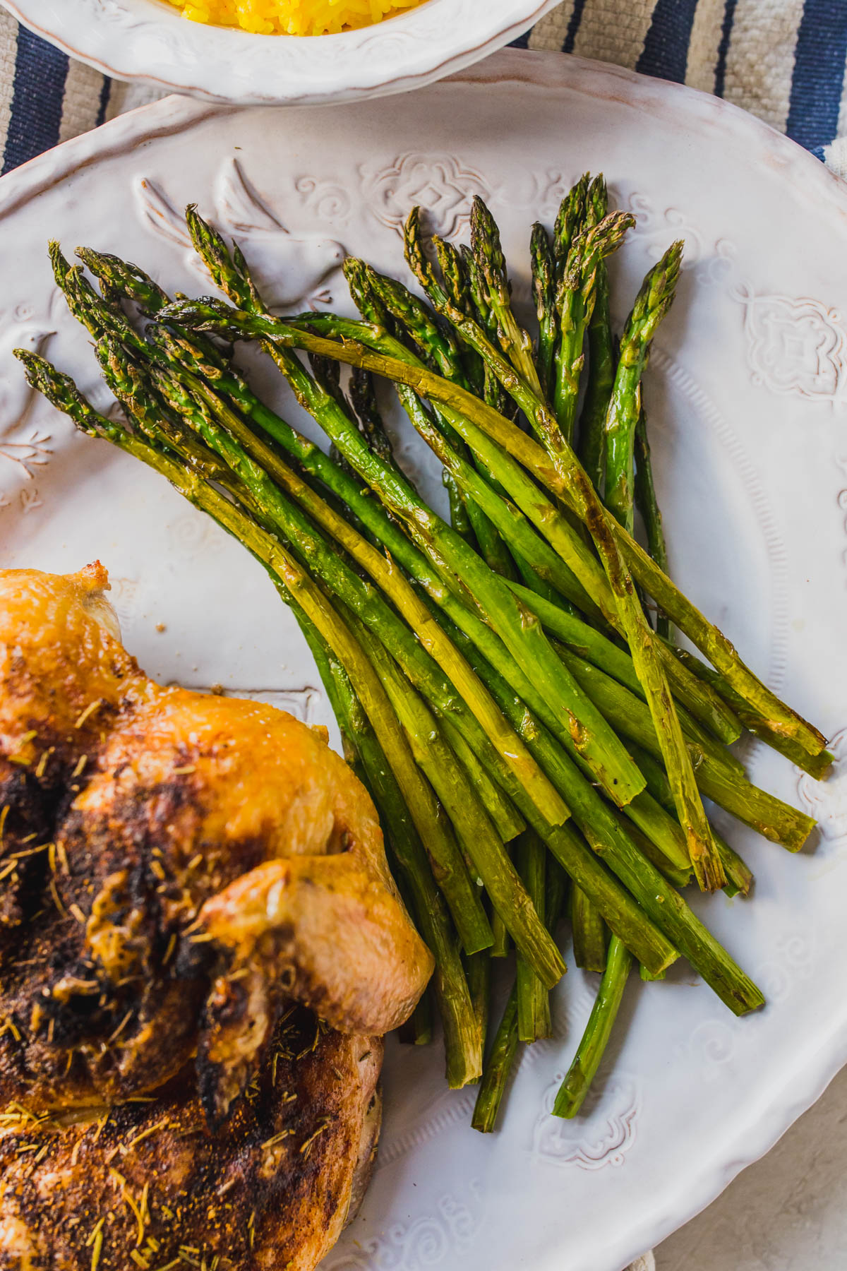 This easy oven roasted whole chicken is a perfect healthy dinner recipes for the family. I served it with easy saffron rice and oven roasted asparagus to keep the ingredients to a minimum. You probably already have the spices in your pantry too! Make easy homemade chicken stock from the bones for a a no waste recipe! Click through for the recipe for this whole roasted chicken with vegetables. #healthydinners #easydinnerideas