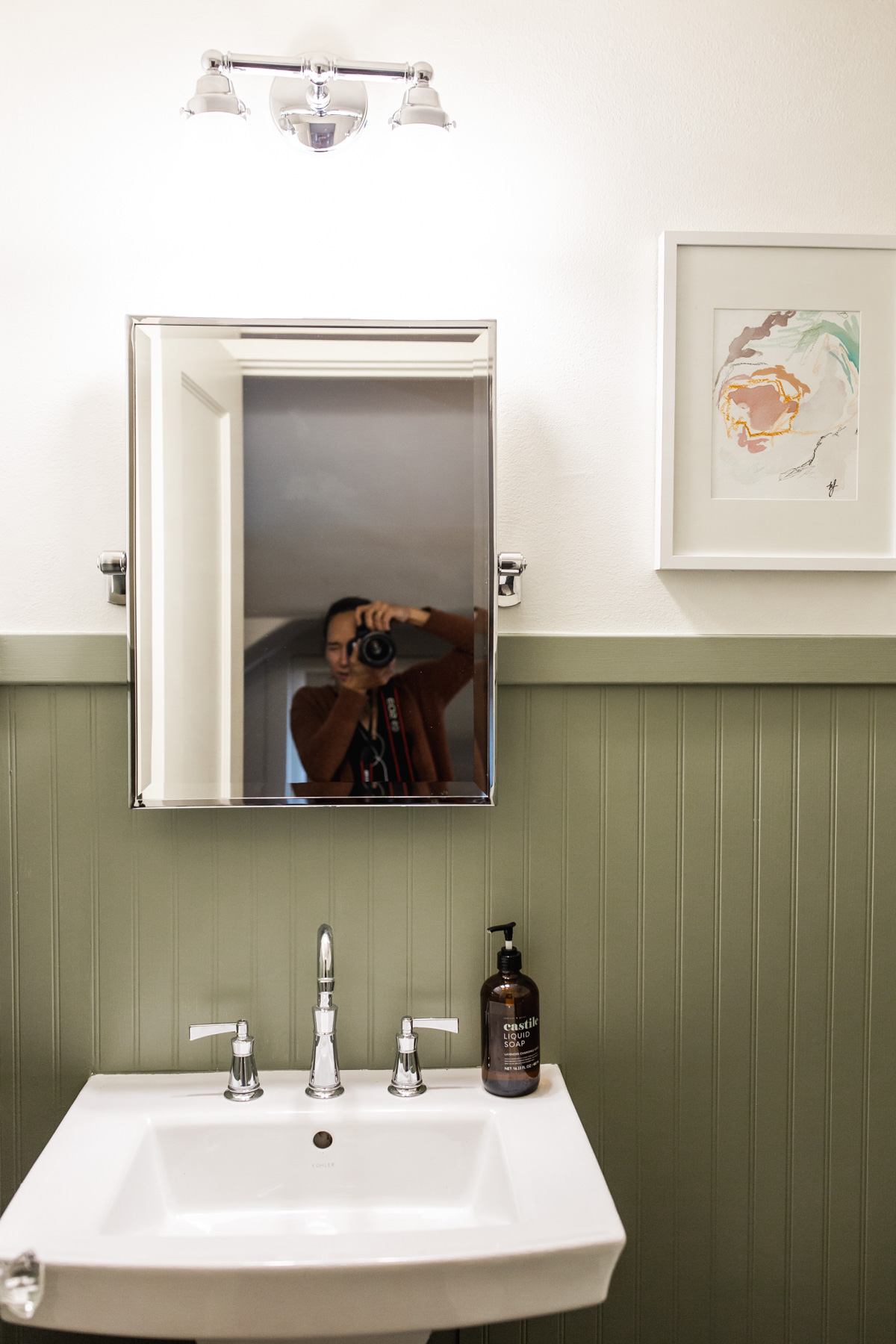 woman waking a photo of added Beadboard to a Bathroom