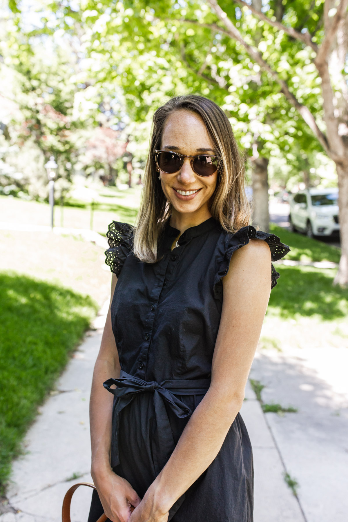 woman smiling and wearing sunglasses and black dress for $40 Dresses for Summer
