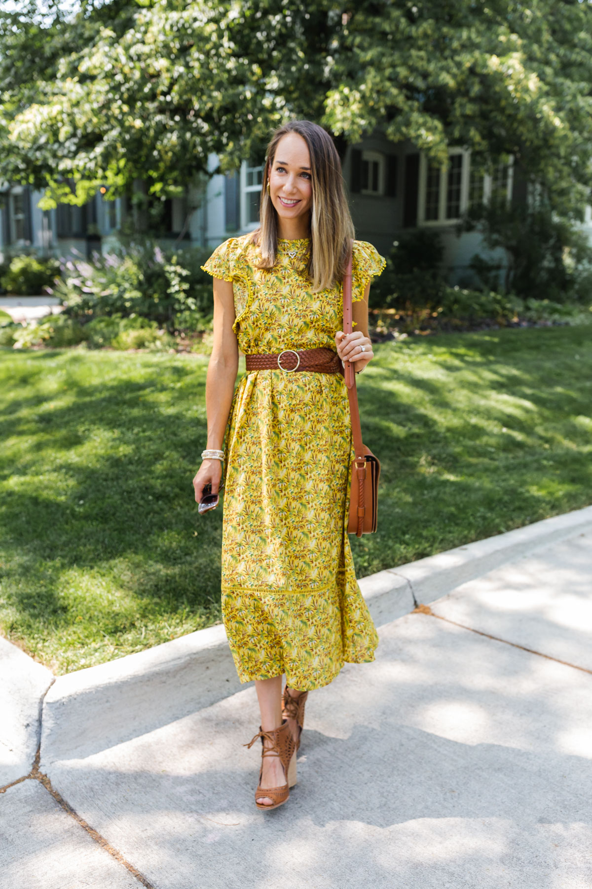 woman smiling, wearing printed dress to what to wear to a baby shower