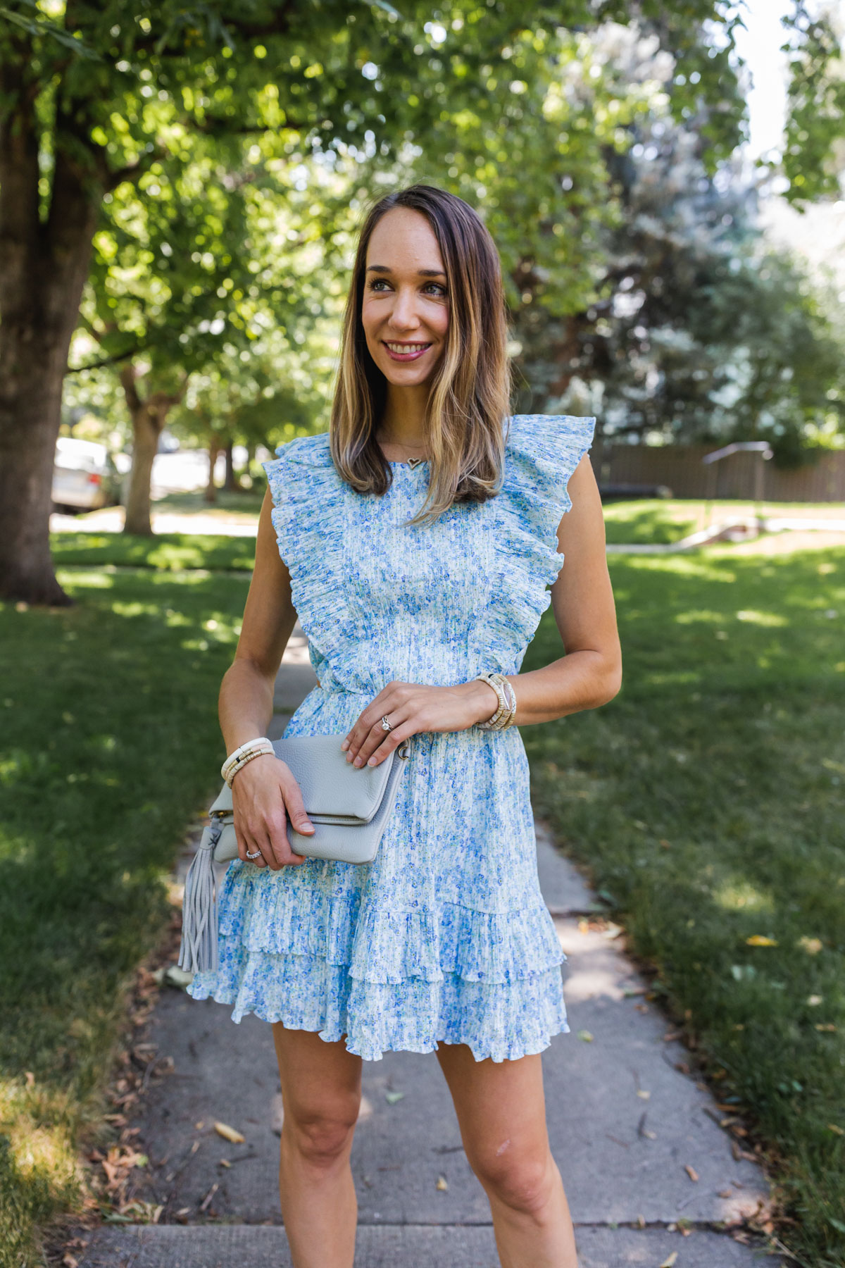 woman smiling and wearing wedding guest dress for summer in blue